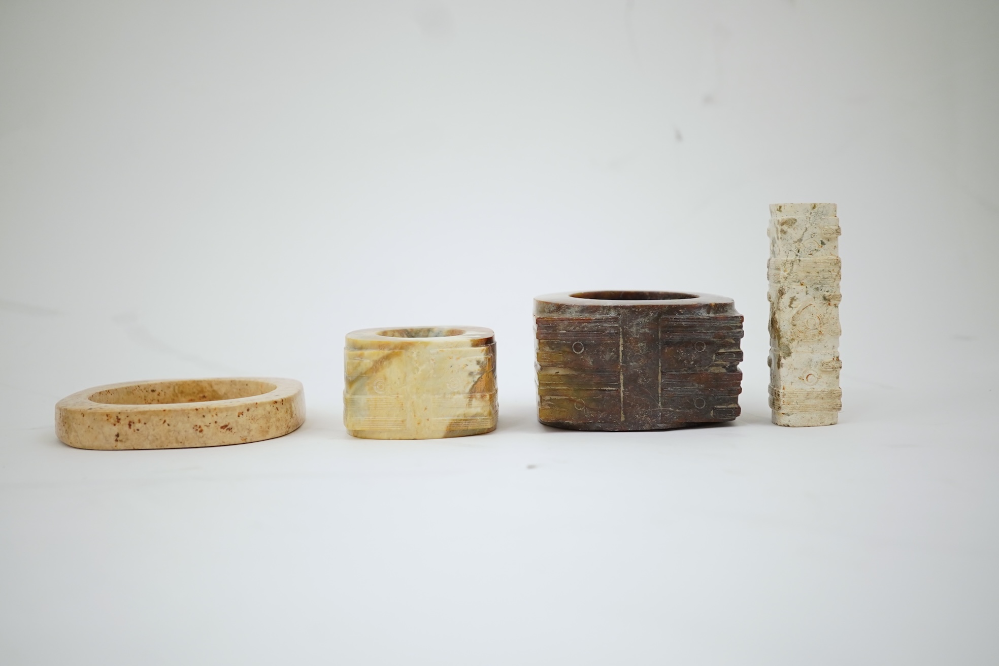 Four Chinese archaistic hardstone or burnt jade cong or cylinders